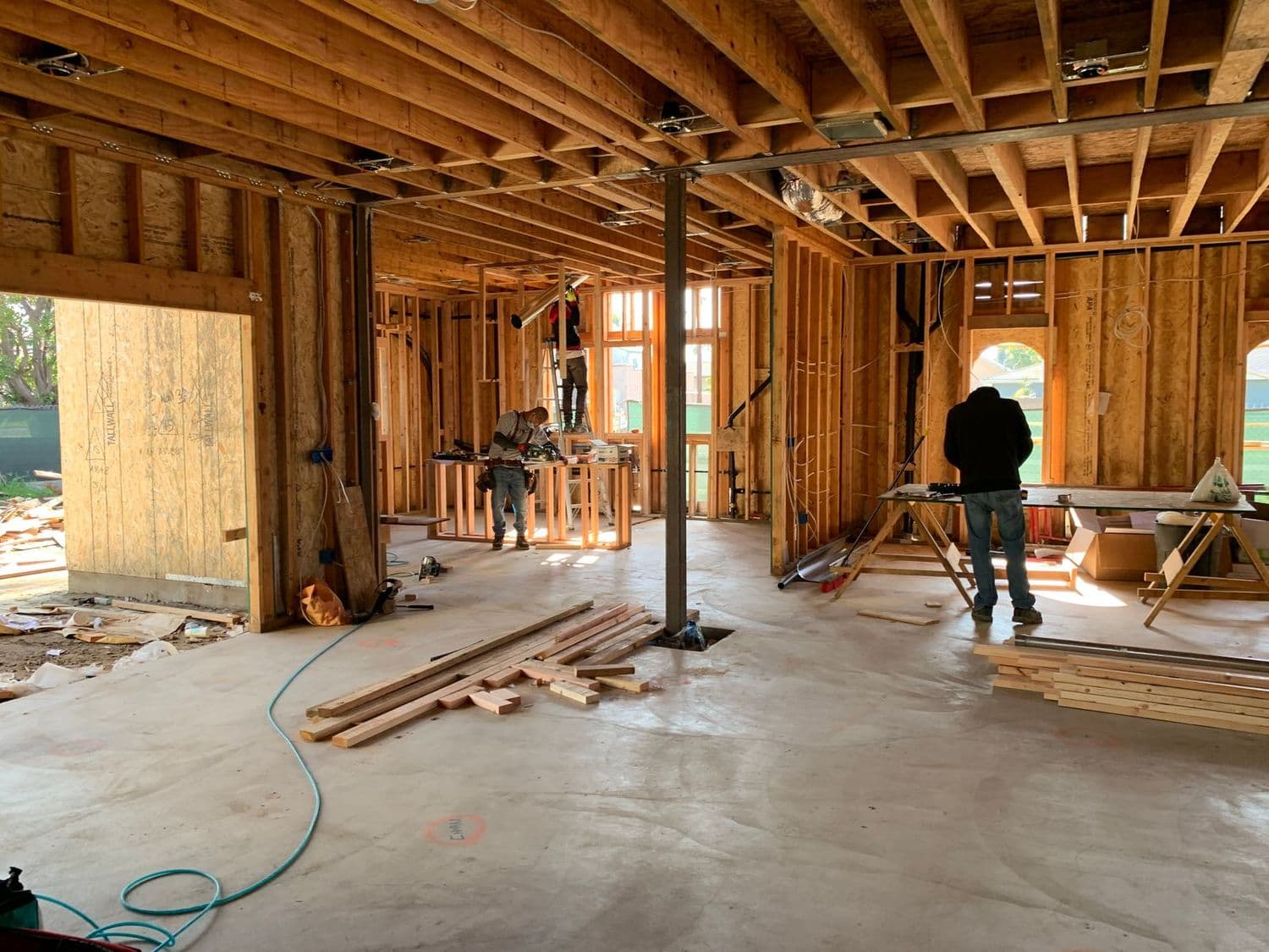 Workers on the framed interior of a house under construction